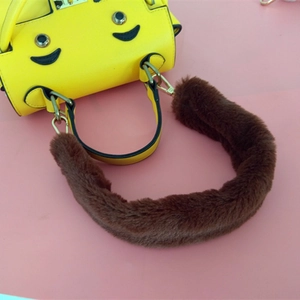 Détail d'une bandoulière en fausse fourrure marron sur un sac en cuir jaune à motif