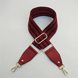 Détail de la bandoulière tissée rouge et noire avec boucles en métal doré brillant