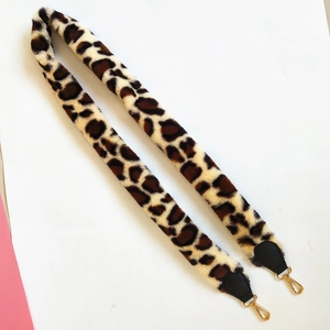 Detailed view of leopard print faux fur shoulder strap with golden metal buckles