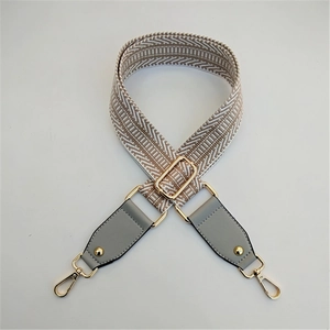 Detail view of the woven replacement handbag strap with golden lobster clasps and buckles