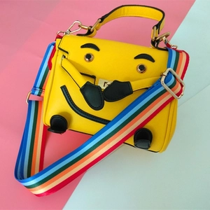 Yellow cartoon face leather handbag with colorful wide rainbow woven shoulder strap