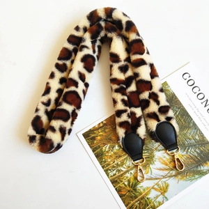 Close-up of leopard print faux fur handbag strap with golden metal lobster clasps