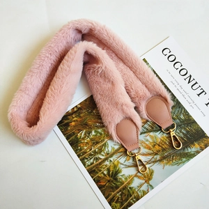 Close-up of pink faux fur shoulder strap with golden metal lobster clasps and leather trim