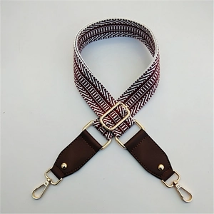 Detail view of woven pattern and brown leather ends with golden metal buckle