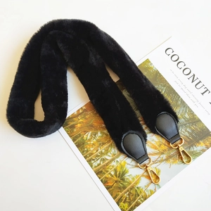 Close-up of black faux fur bag strap with gold metal lobster clasps and leather ends
