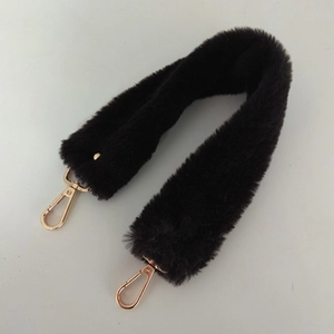 Bandoulière en fausse fourrure pelucheuse avec fermoirs métalliques dorés sur fond blanc