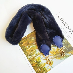 Detail of dark blue faux fur shoulder strap with gold metal lobster clasp and leather joint