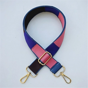 Detail of adjustable woven bag strap with multicolor blocks and gold metal clips