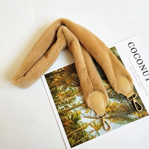 Detailed view of the soft faux rabbit fur strap in camel with golden metal lobster clasps