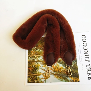 Detail of dark brown faux fur shoulder strap with golden metal lobster clasps
