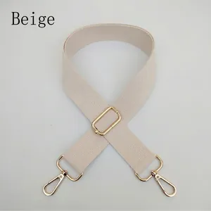 Close-up of adjustable beige woven bag strap with premium gold metal lobster clasps