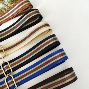 Adjustable wide shoulder straps with iconic red and green stripes and gold buckles