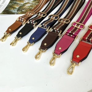 Close-up of adjustable striped canvas replacement bag straps with golden metal hooks