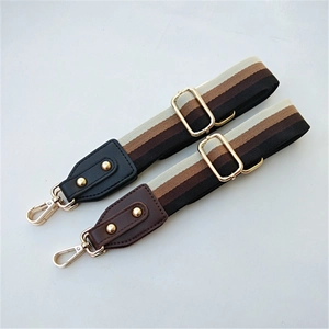 Close-up of woven ethnic striped bag strap with leather ends and golden metal hardware