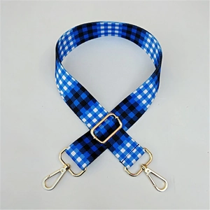 Close-up of adjustable blue and black gingham canvas bag strap with gold metal hardware