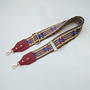 Close-up of geometric woven strap with gold metal hooks and red leather details
