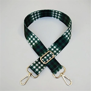 Close-up of green checkerboard canvas bag strap with golden metal lobster clasps