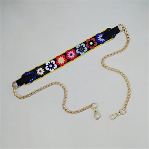 Close-up of floral embroidery strap with golden metal chain and lobster clasps