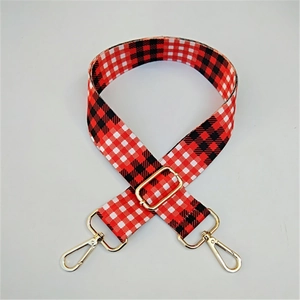 Macro detail of red buffalo plaid canvas strap with gold metal lobster clasps