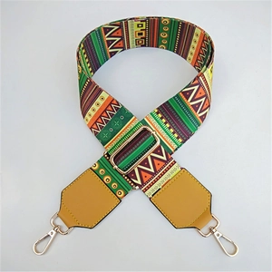 Macro detail of wide ethnic style woven strap with geometric patterns and golden metal hooks