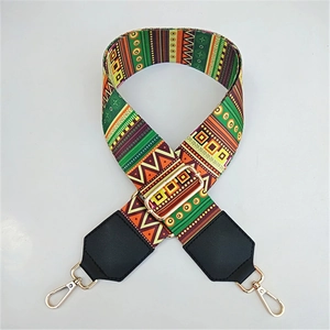 Detail of adjustable woven wide bag strap with colorful ethnic pattern and gold metal hooks
