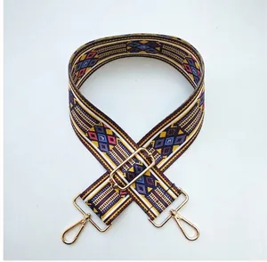 Detail of wide ethnic style woven bag strap with colorful stripes and gold hardware