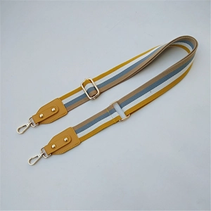 Close-up of the colorful striped woven bag strap with golden metal lobster clasps