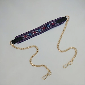Close-up of colorful ethnic embroidery purse strap with gold metal chain and lobster clasps