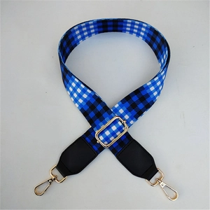 Detail of adjustable blue and black checkered bag strap with gold metal swivel hooks