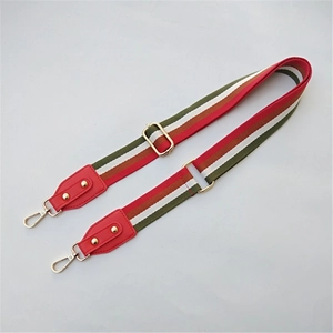 Detail of adjustable wide striped strap with golden hardware and red leather ends