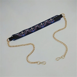 Close-up of colorful ethnic embroidery strap with golden metal chain and lobster clasps