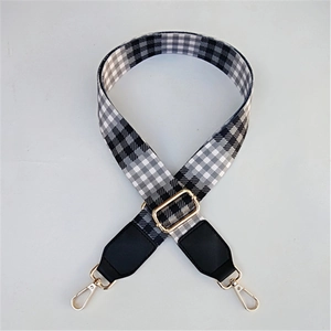 Detail of adjustable black and grey gingham bag strap with gold metal swivel clasps