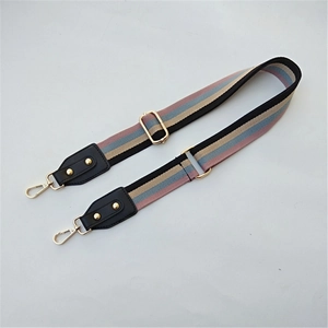 Detail view of ethnic striped wide shoulder strap with golden metal hardware and black leather