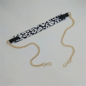 Detail of leopard print webbing combined with golden metal chain strap and lobster clasps