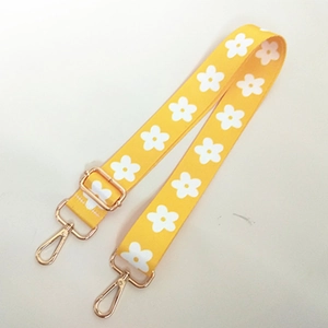 Détail de la bandoulière jaune réglable avec motif marguerites et fermoir doré en métal