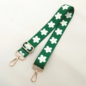 Détail de la bandoulière verte à fleurs marguerites avec boucle dorée réglable