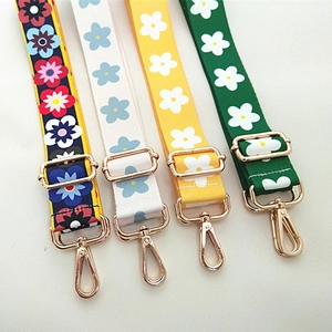 Détail de bandoulières tissées à fleurs avec boucles dorées réglables pour sacs