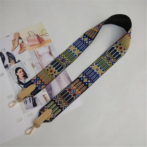Close-up of ethnic embroidered wide shoulder strap with golden metal buckles