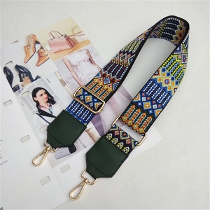 Detail of colorful geometric woven bag strap with golden lobster clasp and leather end