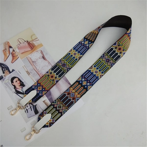 Macro shot of bohemian embroidered strap with colorful geometric patterns and gold metal hooks