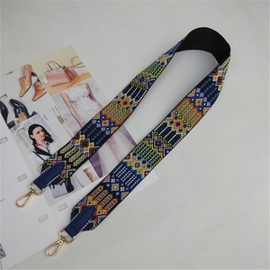 Close-up of ethnic geometric weave shoulder strap with navy leather and gold hardware