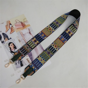 Close-up of ethnic style embroidered bag strap with golden metal lobster clasps