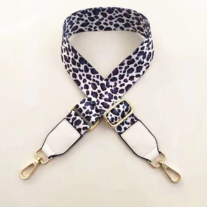 Detail of purple leopard print wide shoulder strap with gold hardware and leather ends