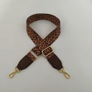 Detail of adjustable leopard print bag strap with wide webbing and golden metal lobster clasps