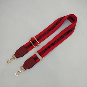 Close-up of adjustable red fabric shoulder strap with gold metal lobster clasps
