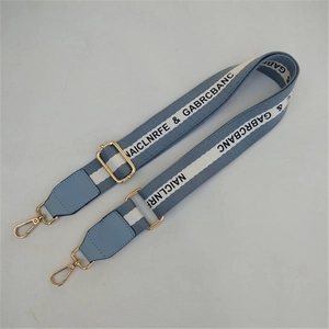 Detail of adjustable blue and white striped bag strap with gold metal hooks
