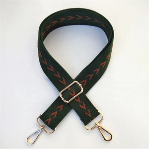 Détail d'une bandoulière ethnique réglable avec tissage vert et motifs en V orange