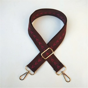 Détail de la bandoulière ethnique café avec motif V rouge et crochets dorés en métal