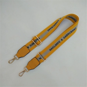 Adjustable yellow crossbody strap with black lettering and gold metal buckles