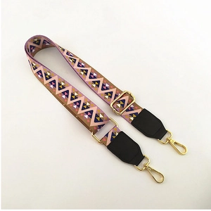 Detail of colorful geometric woven strap with gold metal buckles and leather ends